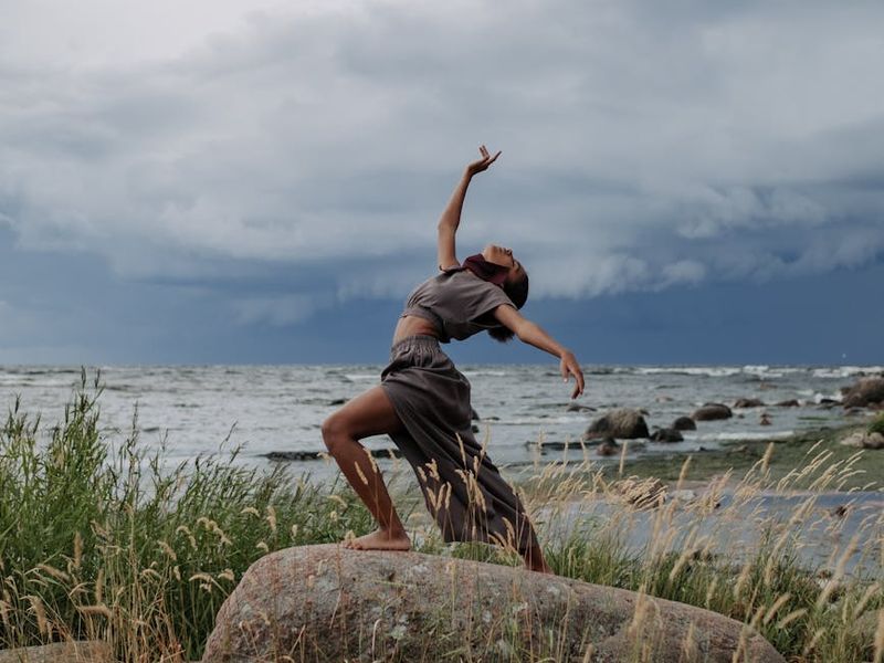 Person in a fluid motion pose against a dark background.